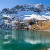 Lac d'altitude aux eaux turquoise, reflets des montagnes enneigées. Idéal pour une randonnée à Ceillac par temps ensoleillé.