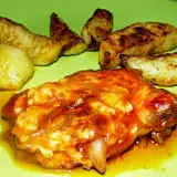Karkówka pieczona w plastrach z majonezem i ketchupem, podana z pieczonymi ziemniakami. Pyszne danie na obiad.