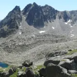 Majestuosas montañas rocosas y un lago azul turquesa en el valle de Aneu.