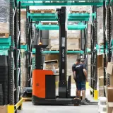 Wózek widłowy w magazynie, pracownicy przygotowują towar do wysyłki. Efektywny outbound logistics.