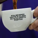 Tazza bianca con scritta "Stai bevendo caffè di filiera ad alto impatto positivo". Un caffè speciale che fa bene.