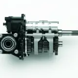 Mechanizm zmiany biegów z widocznymi kołami zębatymi i wałkami, pokazujący, jak działa skrzynia biegów.