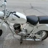 Ciclomotor histórico blanco, modelo Iso, con asiento doble y detalles cromados.