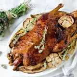 Pieczona kaczka z czosnkiem i ziołami. Idealne jakie przyprawy do kaczki? Tymianek i czosnek nadają jej wspaniały aromat.