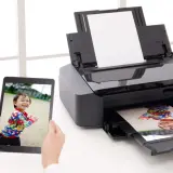 Drukarka atramentowa drukuje zdjęcie dziecka z tabletu. Wybór odpowiedni jaki papier fotograficzny do drukarki atramentowej zapewni najlepszą jakość.