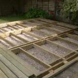 Solidne legary pod taras, z uwzględnieniem wymiarów, tworzą stabilną konstrukcję na podsypce żwirowej.