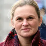 Barbara Nowacka, z uśmiechem na twarzy, w wieku, który świadczy o doświadczeniu życiowym.