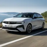 Biała Opel Astra Hybrid na krętej drodze nad morzem.