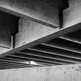 Skomplikowana konstrukcja z betonu, z widocznymi belkami i żebrowaniem. Ta klasa betonu tworzy surowy, architektoniczny krajobraz.