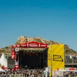 Gran concierto en la costa Sonora, con un escenario imponente y una multitud disfrutando bajo el sol.