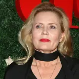 Grażyna Szapołowska, ile lat ma? Aktorka z czerwoną szminką i czarnym szalem na tle zielonej choinki.