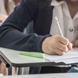 Uczeń pisze wypracowanie, ćwicząc użycie gerund i bezokolicznika.