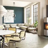 Poêle à bois moderne dans un salon lumineux avec canapé et table à manger.
