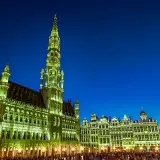 Wieczorem na Grand Place w Brukseli, oświetlone ratusz i kamienice tworzą magiczny widok.