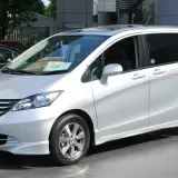 Srebrny Honda Freed stoi na tle budynku.