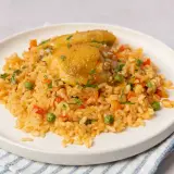 Plato de arroz con pollo, zanahorias, guisantes y pimientos rojos. Una deliciosa receta de arroz con pollo lista para servir.