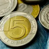 Monety 5 zł, 2 zł i 1 zł na tle banknotu. Czy to zapowiedź średniej krajowej 2026?