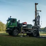 Ciężarówka z wiertnicą na działce, gotowa do wiercenia studni. Tak można znaleźć wodę na działce.