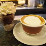 Deser z bitą śmietaną i kawa latte, jakby zrobione z tazza d'oro.