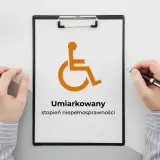 Na tablicy widnieje symbol osoby na wózku inwalidzkim i napis "Umiarkowany stopień niepełnosprawności".