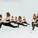 Grupo de mujeres realizando estocadas, parte de **15 ejercicios de calentamiento** para preparar el cuerpo.