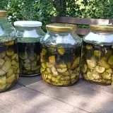 Słoiki z orzechówką na żołądek, przygotowaną z zielonych orzechów włoskich.