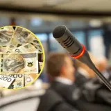 Ile zarabia radny w Warszawie? Na stole leżą banknoty 200 zł, a przed mikrofonem siedzą ludzie.