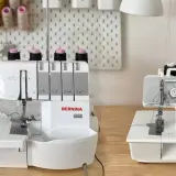 Two Bernina overlock machines, a serger vs overlock comparison, sit on a wooden table.