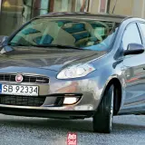 Szary Fiat Bravo 2 z tablicą rejestracyjną SB 92334 na tle budynku.