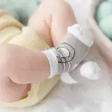 Nóżka niemowlaka w skarpetkach z motywem misia.