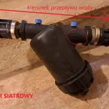 Filtr dyskowy z zaznaczonym kierunkiem przepływu wody. Widoczny symbol "SCREEN" na obudowie.
