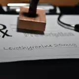 Recept na leki, na którym widnieje "Levothyroxine 25mcg". Obok stetoskop i pieczątka.