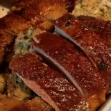 Gęś Ania gotuje. Pyszna, pieczona gęś z chrupiącą skórką i aromatycznym farszem, pokrojona na kawałki.