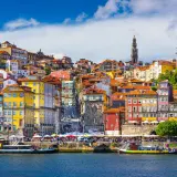 Kolorowe kamienice Porto nad rzeką, z widokiem na wieżę i kościoły. Marzenie o lotach z Gdańska do Porto.