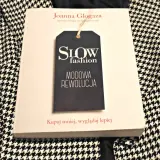 Książka "Slow fashion. Modowa rewolucja" Joanny Glogazy na tle wzorzystej tkaniny. Inspiracja dla polskich marek slow fashion.