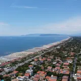 Vista aerea della costa toscana, dove si trova Forte dei Marmi, con spiagge attrezzate, mare blu e un fitto tessuto urbano.