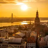 Zachód słońca nad Rygą. Widok na katedrę, most i nowoczesne budynki. Warto zobaczyć w Rydze to miasto pełne kontrastów.