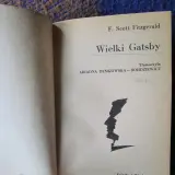 Strona tytułowa "Wielkiego Gatsby'ego" F. Scotta Fitzgeralda. Czarno-biała grafika profilu twarzy.