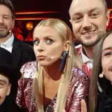 Uśmiechnięci jurorzy Voice of Poland w barwnych strojach, gotowi oceniać talenty.