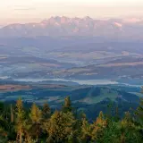 Widok z lubań szczyt na Tatry o wschodzie słońca. Mgły unoszą się nad doliną, a lasy i pola tworzą malowniczy krajobraz.