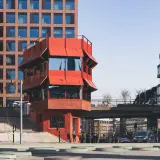 Rött, unikt hus vid Sergels torg, med trappor och moderna byggnader runtom. En plats för bio och möten.
