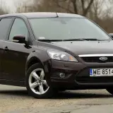 Ciemnobrązowy Ford Focus 2 kombi stoi na drodze.