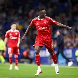 Piłkarz Sevilli w czerwonej koszulce wskazuje palcem, analizując statystyki meczu Getafe CF – Sevilla FC.