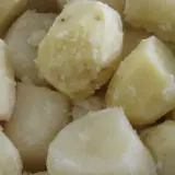 Ugotowane ziemniaki, niektóre lekko posiniaczone, wyjaśniające, dlaczego ziemniaki po ugotowaniu sinieją.