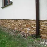 Kamienny cokół domu, ozdobiony naturalnym kamieniem, chroni ściany i dodaje uroku.