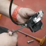 Mecánico ajusta pinza de freno, pensando cuánto duran unas pastillas de freno.