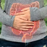 Personne tenant son ventre, avec une image superposée d'intestins rouges. Selles liquides comme de l'eau que faire ?
