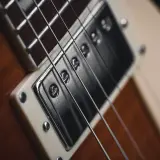 Zbliżenie na przetwornik i struny gitary elektrycznej, idealne do tworzenia eterycznego shoegaze.