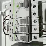 Budowa przewodu elektrycznego: zabezpieczenia nadprądowe Noark i podłączone przewody w rozdzielnicy.