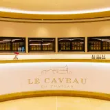 Le caveau Guigal, un comptoir moderne avec des bouteilles de vin exposées dans des vitrines lumineuses.
